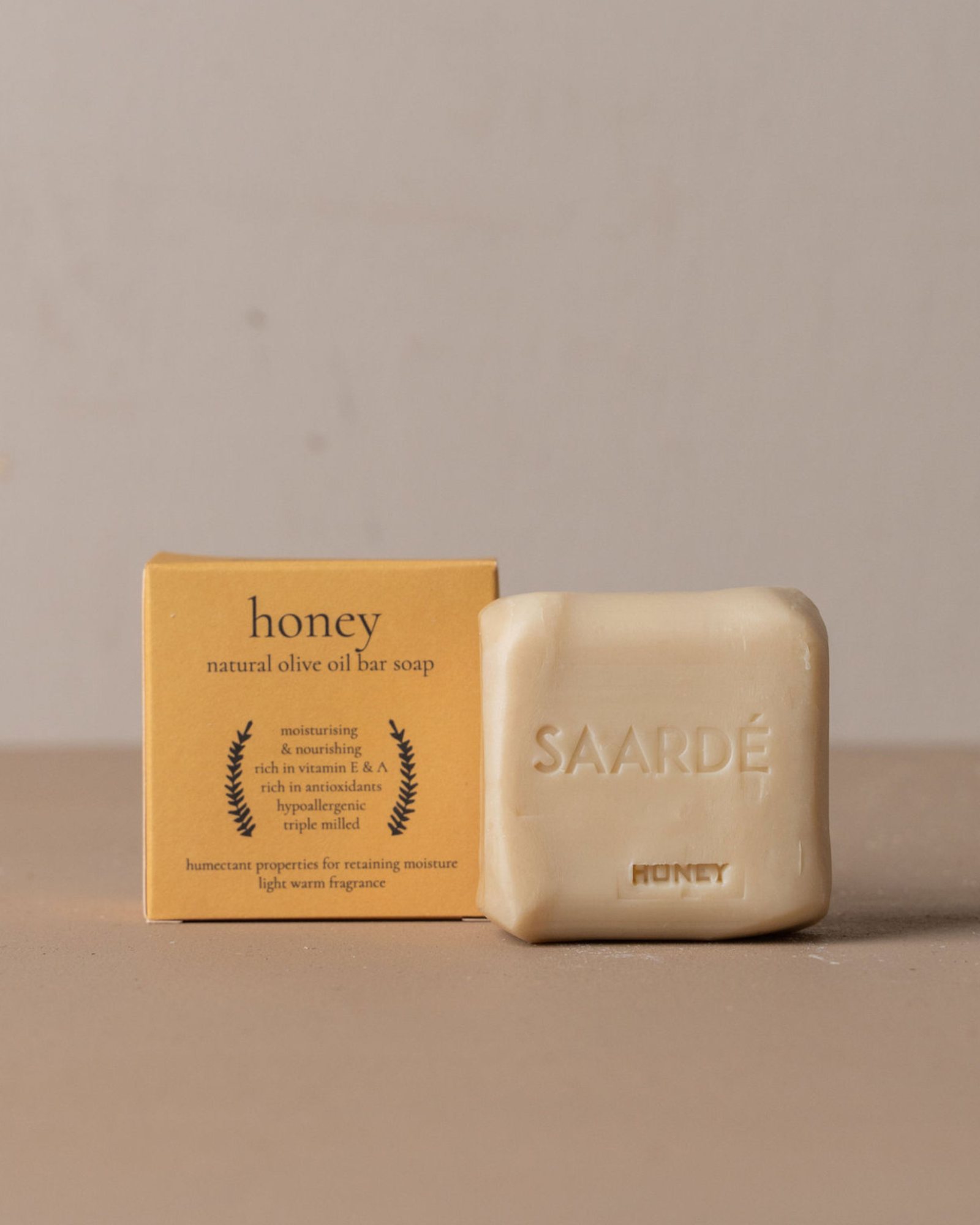 Honey natural olive oil bar soap with packaging on a beige background