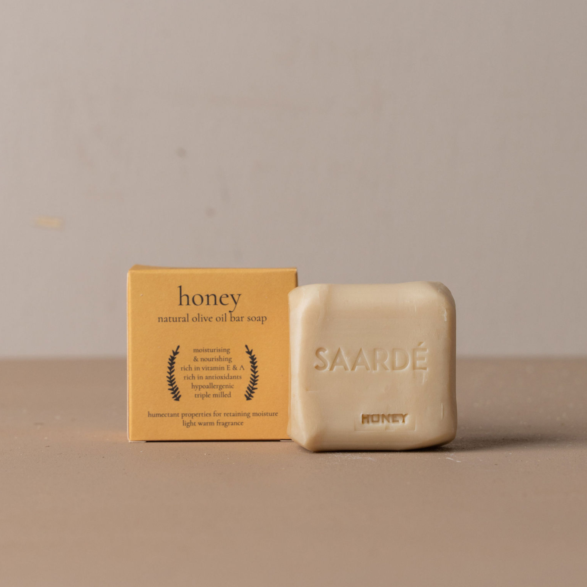 Honey natural olive oil bar soap with packaging on a beige background