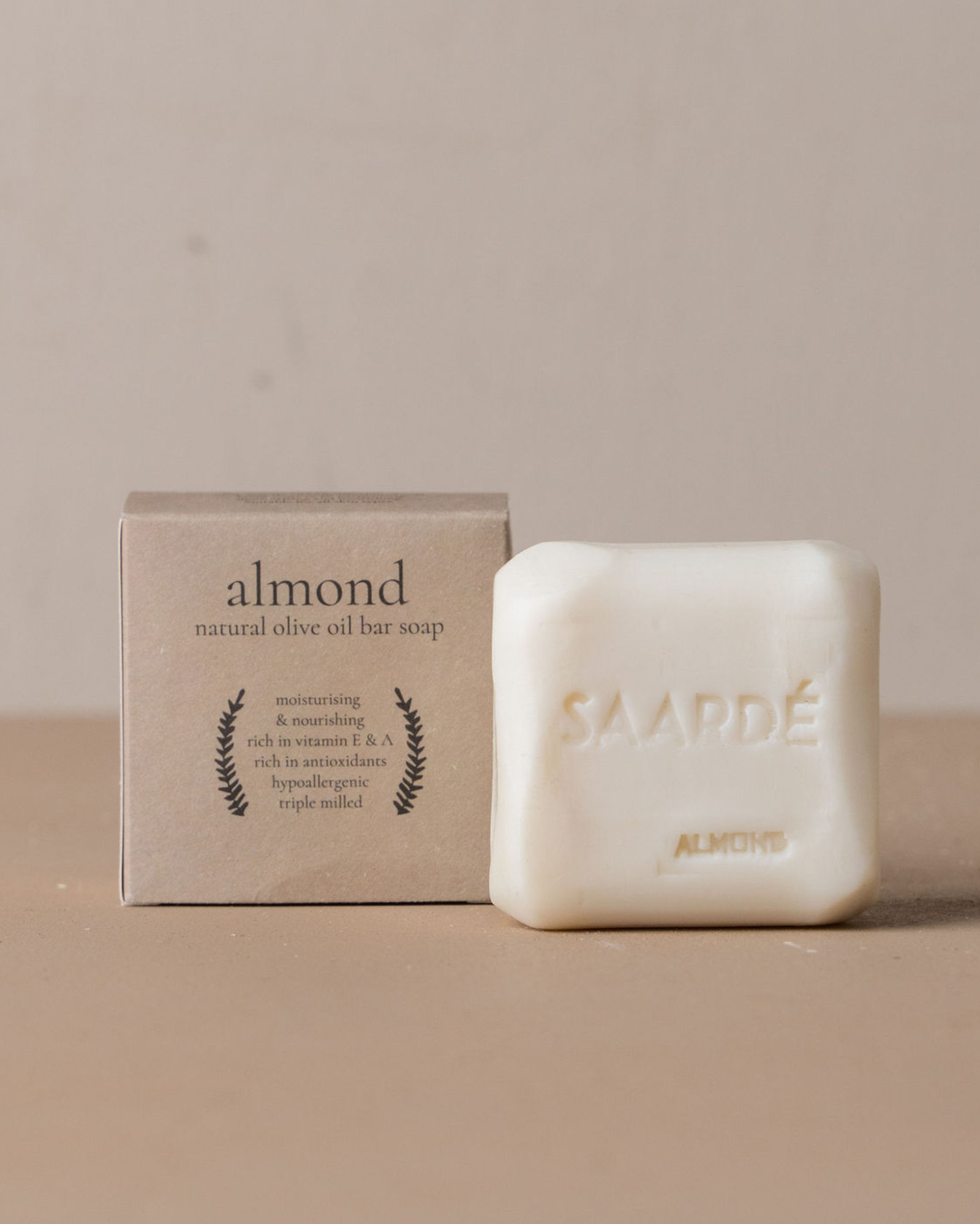 Almond natural olive oil bar soap with packaging on a beige background