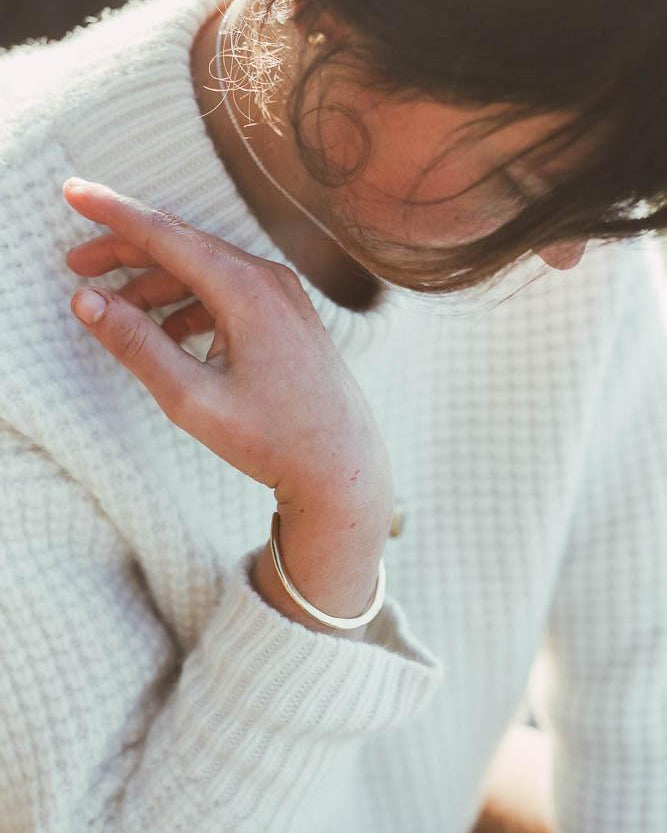 brass bracelet worn by model in artful pose