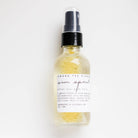 Bottle of 'Sun Spirit' after sun body mist with a white label on a light gray background