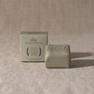 Clay natural olive oil bar soap with packaging on a beige fabric background