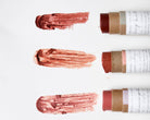 Lip balm sticks with swatches of color on a white background