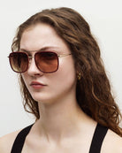 Woman wearing sunglasses with a neutral background