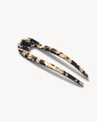 French hair pin with black, white and cream marbled pattern on a white background.