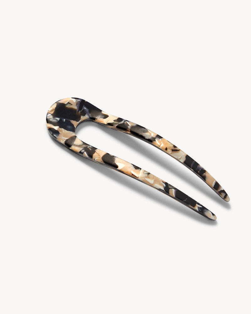French hair pin with black, white and cream marbled pattern on a white background.