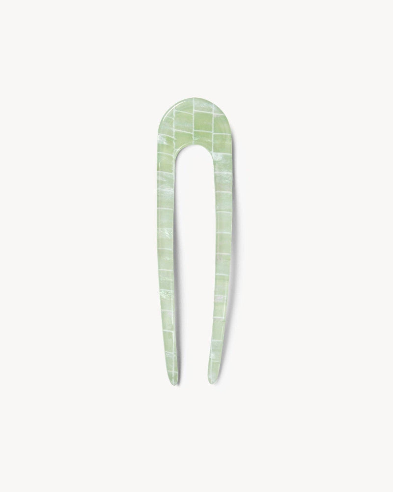 Green checkered hair pin on a white background
