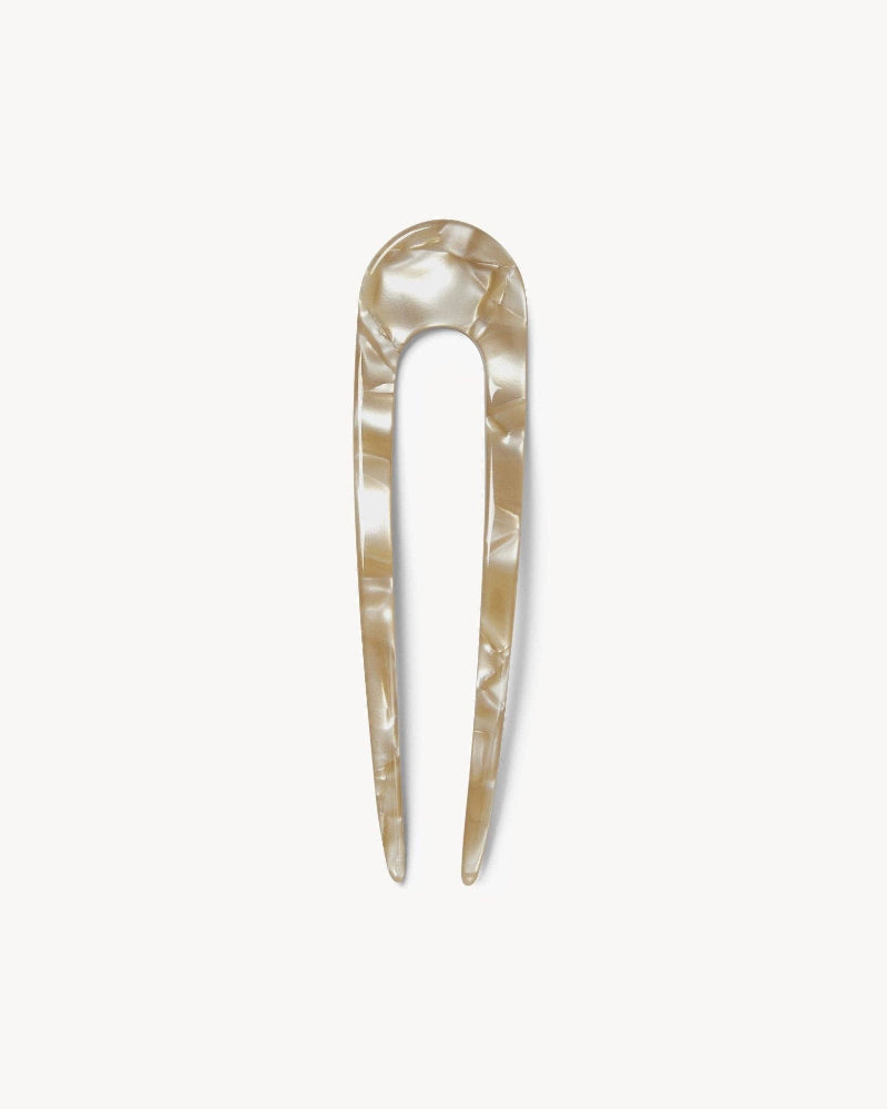 A beige French hair pin made of acetate, displayed against a white background.
