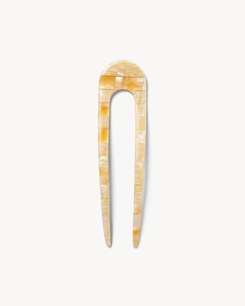 Decorative hair pin with a checkered shell pattern on a white background