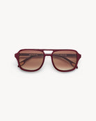 Maroon sunglasses with a brand logo on a white background