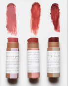 Set of lip balm sticks with swatches on a white background