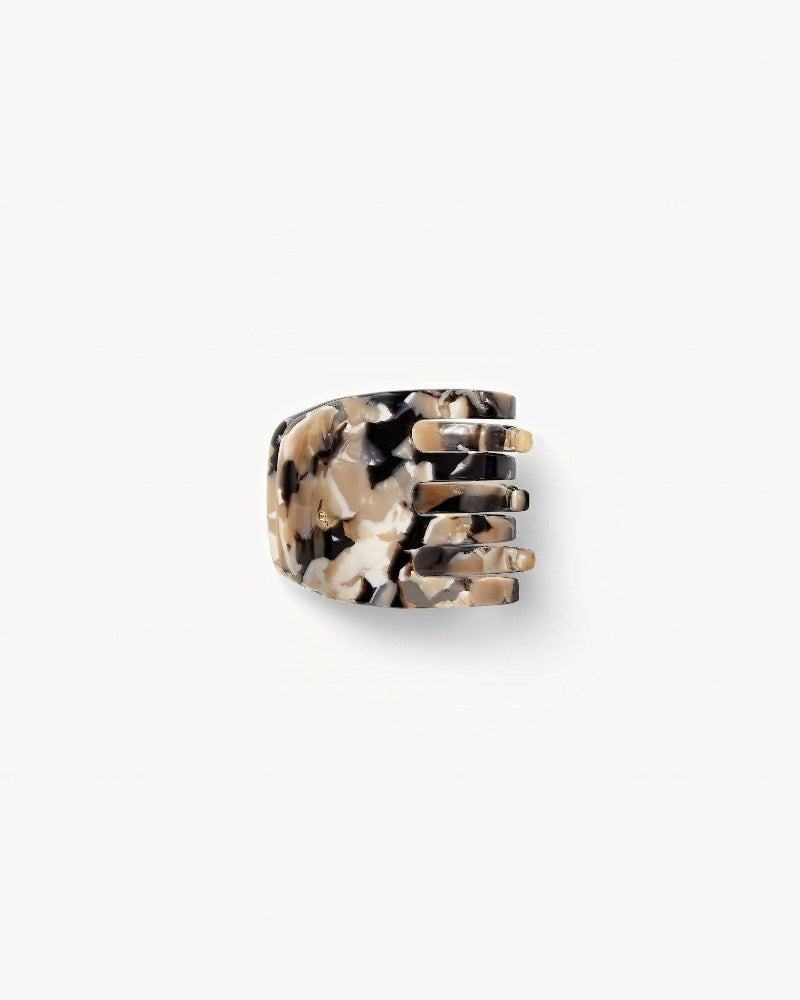 A handcrafted mini claw clip with a pattern resembling abalone shell, in shades of beige, black, and brown.