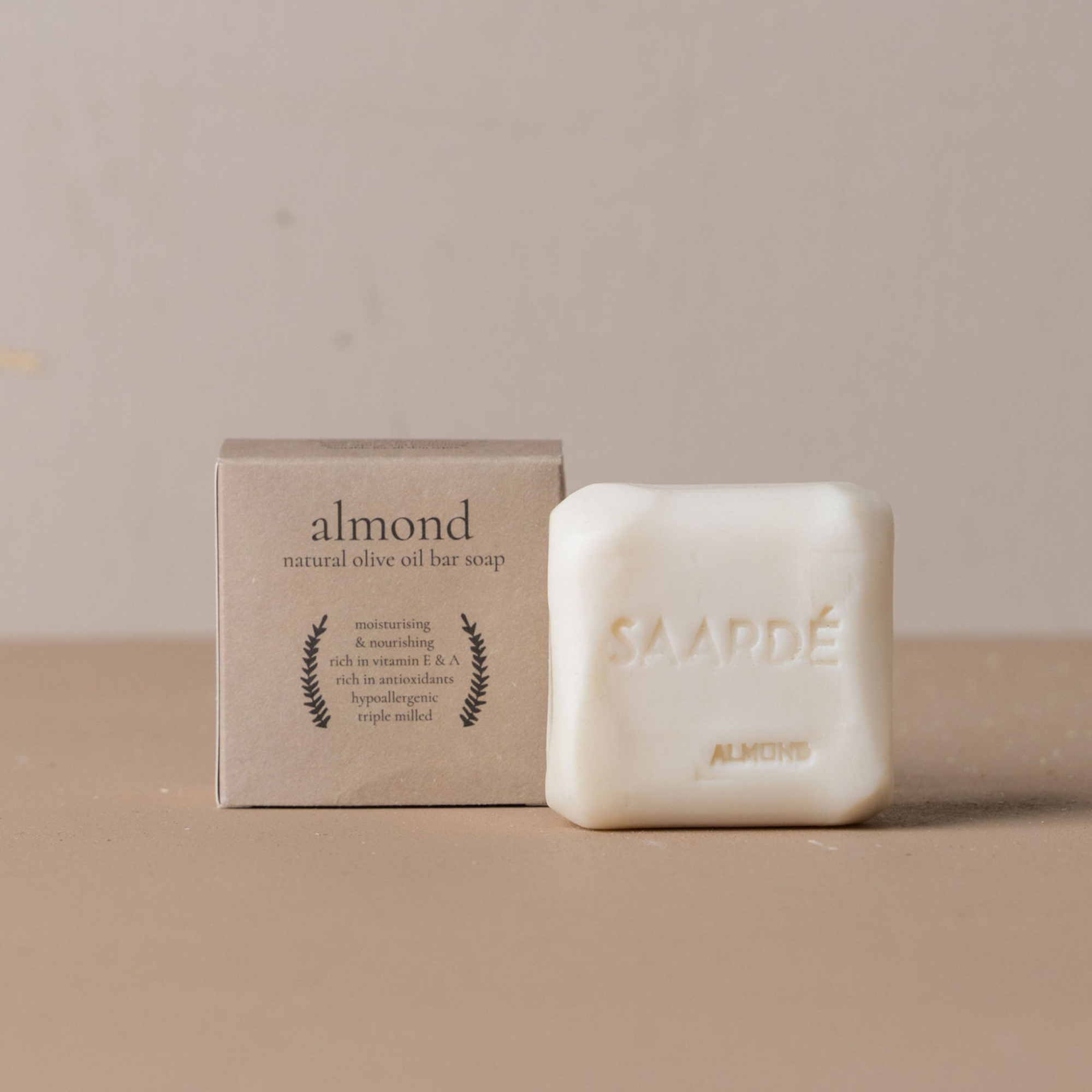 Almond natural olive oil bar soap with packaging on a beige background