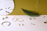 nature inspired brass gold jewelry collection stylize photo with fern, mirror and gold backdrop