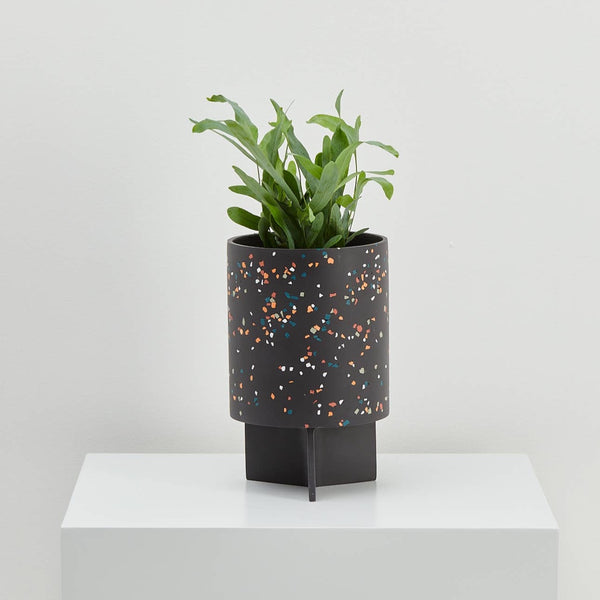 Black terrazzo pedestal planter with unique drainage tray.