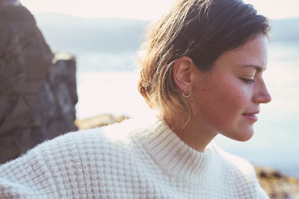 model on beach wearing circle stud earrings
